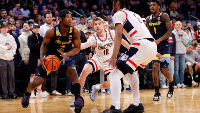 Chase Ross #2 of the Marquette Golden Eagles dribbles as Cam Spencer #12 and Stephon Castle #5 of the Connecticut Huskies defend.